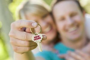 Couple Holding House Key with New Home Text photo