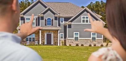 House and Military Couple Framing Hands in Front photo