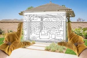 contratista masculino manos enmarcando sección de dibujo de pérgola personalizada dibujo de diseño de cubierta de patio foto
