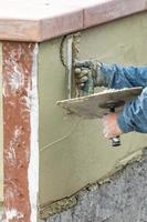 Tile Worker Applying Cement with Trowel at Pool Construction Site photo