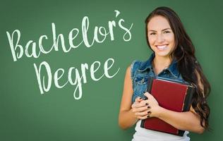 Bachelors Degree Written On Chalk Board Behind Mixed Race Young Girl Student Holding Books photo