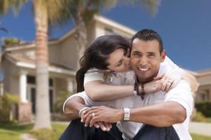 Happy Hispanic Young Couple in Front of Their New Home photo