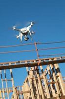 drone quadcopter volando e inspeccionando marcos de madera en el sitio de construcción foto