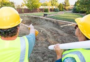 Male and Female Workers Overlooking Pool Construction Site photo