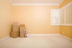 Moving Boxes and Sold Real Estate Sign on Floor photo