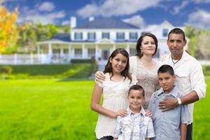 joven familia hispana frente a su nuevo hogar foto