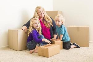 Young Family In Empty Room with Moving Boxes photo