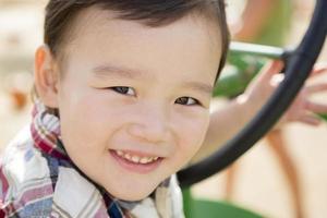 Mixed Race Young Boy Playing on Tractor photo