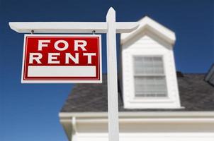 Left Facing For Rent Real Estate Sign In Front of House and Deep Blue Sky. photo