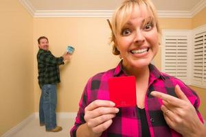 pareja comparando colores de pintura en una habitación vacía foto