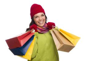 mujer de raza mixta con sombrero y guantes sosteniendo bolsas de compras foto