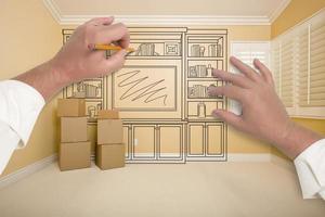 Hands Drawing Entertainment Unit In Room With Moving Boxes photo