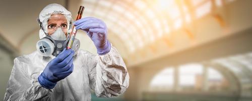 Female Doctor or Nurse In Hazmat Gear Holding Positive Coronavirus Test Tube Banner photo