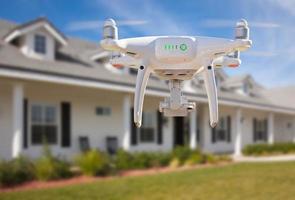 Back of Unmanned Aircraft System Quadcopter Drone Flying In Front of House photo