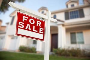 casa en venta signo de bienes raíces frente a casa nueva foto