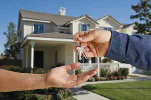 Handing Over the House Keys in Front of New Home photo