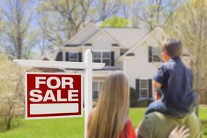 Family Facing For Sale Real Estate Sign and House photo