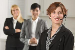 Pretty Red Haired Businesswoman with Headset and Colleagues photo