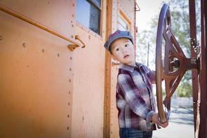 Cute Young Mixed Race Boy Having Fun on Railroad Car photo