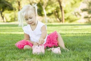 Little Girl Having Fun with Her Piggy Banks Outside photo