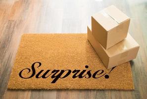 Surprise Welcome Mat On Wood Floor With Shipment of Boxes photo