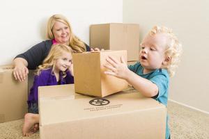 Young Family In Empty Room Playing With Moving Boxes photo