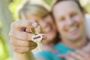 Couple Holding House Key with Home Text photo