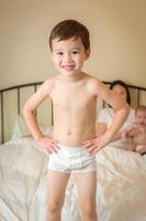 Mixed Race Chinese and Caucasian Boy Jumping In Bed with His Family photo