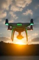 Silhouette of Unmanned Aircraft System Quadcopter Drone In The Air At Sunrise photo