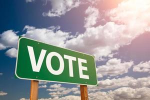 Vote Green Road Sign Over Dramatic Clouds and Sky photo