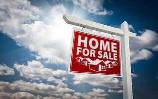 Red Home For Sale Real Estate Sign Over Clouds and Sky photo