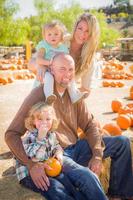 Adorable Young Family Enjoys a Day at the Pumpkin Patch. photo