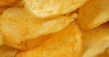 golden potato chips macro closeup, salty crunch snack video