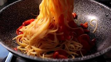 Spaghetti mit Tomate kochen. typisch italienisches essen. Nudeln in einer Pfanne zubereiten. video