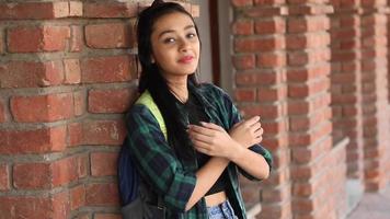 videoclip de una universitaria india adolescente parada con los brazos cruzados en un campus universitario. video