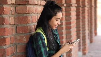 Video of an Asian female college student typing text on her mobile phone and showing the black, empty screen on the camera.