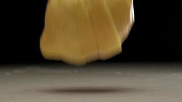 Fresh sliced lemon falling and splashing on water at slow motion video