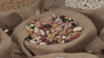 Dry legumes beans falling on jute bowl. Vegan vegetarian Mediterranean food, organic agriculture, healthy nutrition diet video