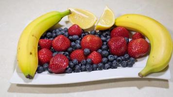 frukt sallad. tropisk friska blanda. färsk jordgubbar, blåbär, banan, citron. vitamin. blandad frukter. video