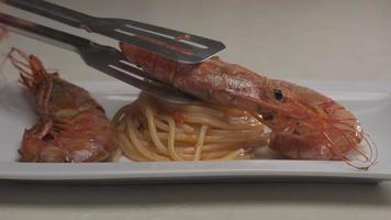 cuisine maison crevettes rouges gastronomiques sur des spaghettis italiens. plat délicieux assiette de crevettes cuites video