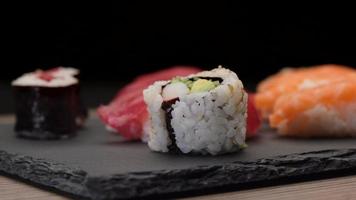sushi sortiment med lax nigiri, tonfisk nigiri, Hosomaki och uramaki. rå fisk maki och ris japansk asiatisk mat. video