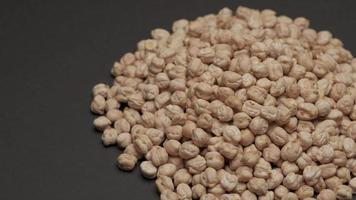 Dry raw uncooked chickpeas legumes rotating on black background. Mediterranean diet, vegetarian or vegan food, healthy nutrition protein video