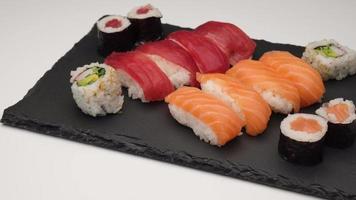 assortiment de sushis avec nigiri au saumon, nigiri au thon, hosomaki et uramaki. maki de poisson cru et riz cuisine asiatique japonaise. video