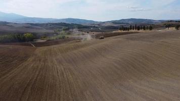 Tractor preparing wheat rural field, plowing ground soil aerial view video