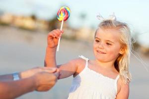 Adorable Little Girl Picking out Lollipop Outside photo