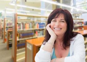 sonriente mujer de mediana edad dentro de la biblioteca foto