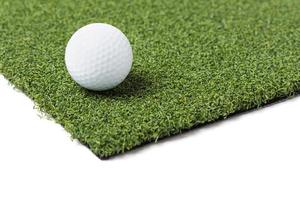 Golf Ball Resting on Section of Artificial Turf Grass On White Background photo