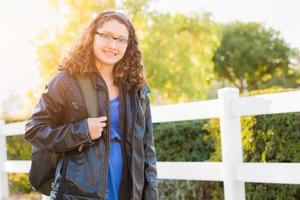 joven hispana caminando al aire libre con mochila foto