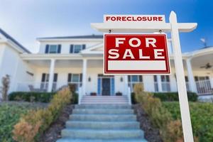 Left Facing Foreclosure For Sale Real Estate Sign in Front of House. photo