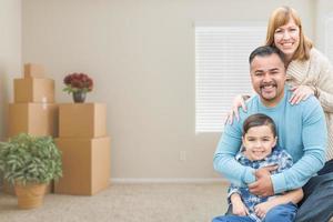 Mixed Race Family with Son in Room with Packed Moving Boxes photo